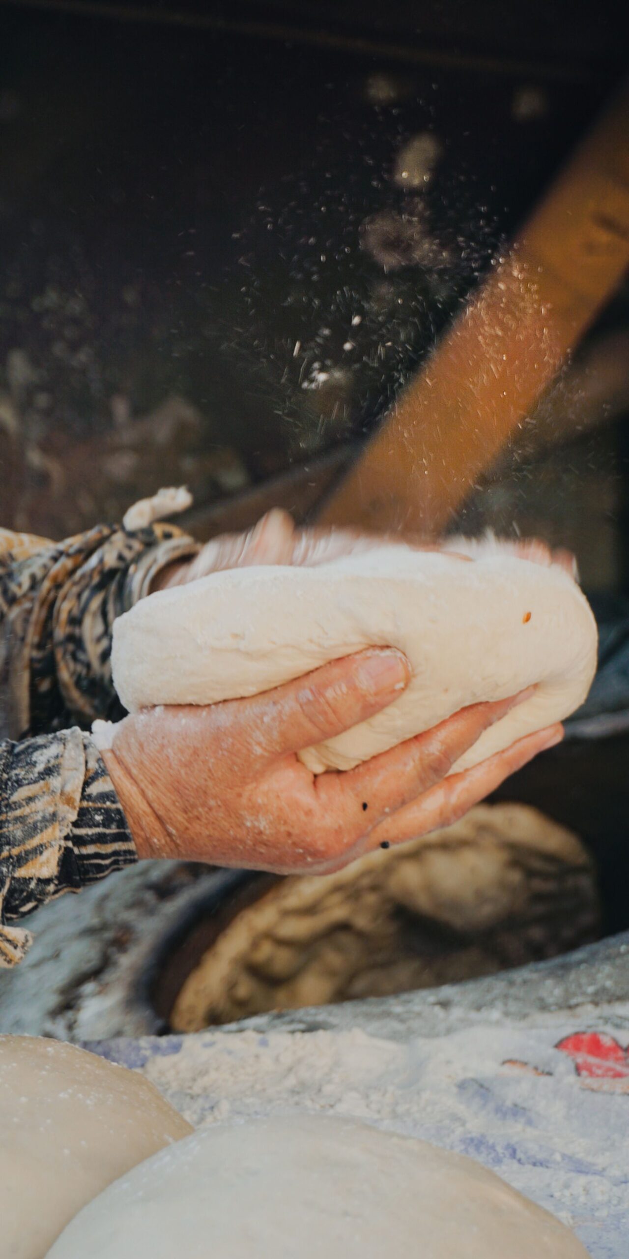 Hands preparing dough in a rustic kitchen in Derik, Türkiye. Capturing traditional bread-making.