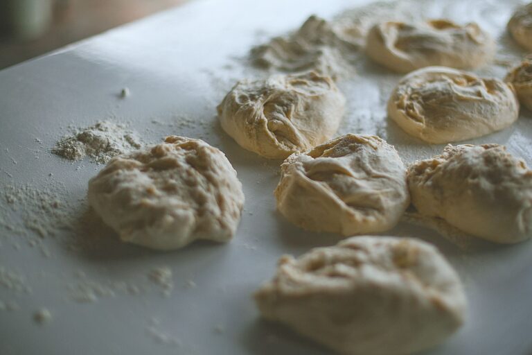From above of fresh round shaped dough for buns on table during cooking process